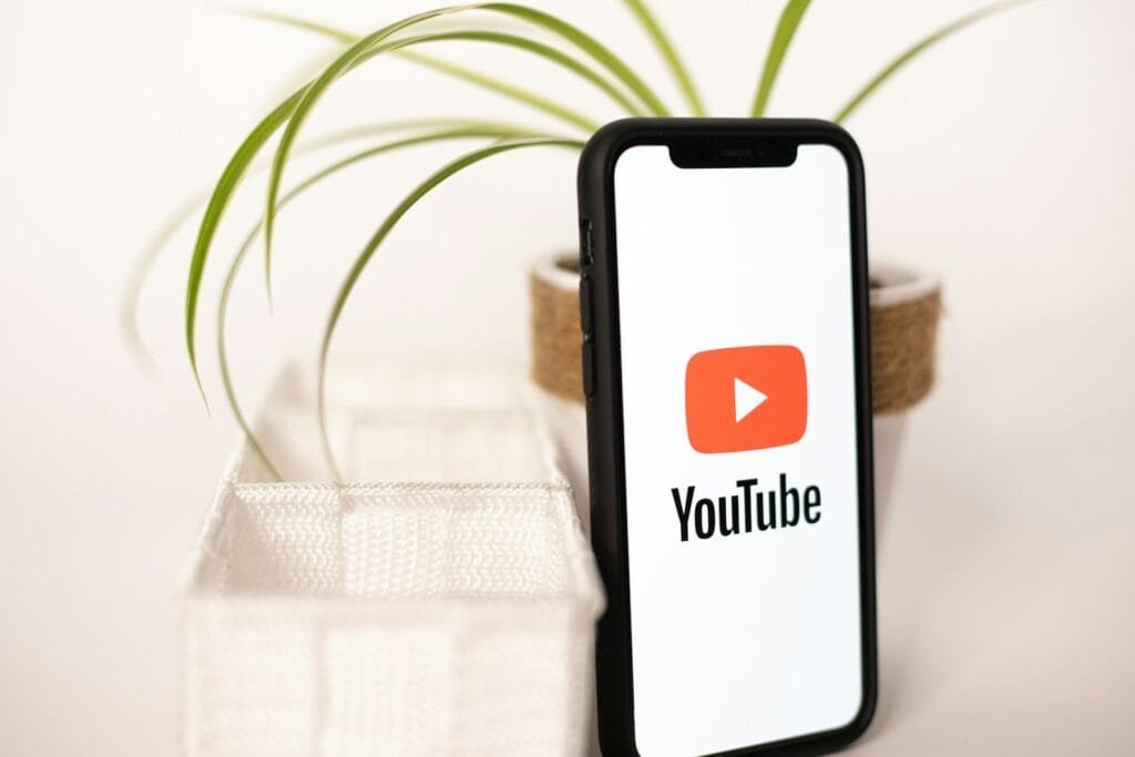 Rank Your YouTube Video: a phone with a youtube logo on it next to a potted plant